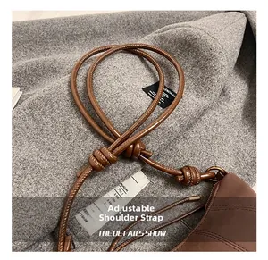 Detail of adjustable knotted shoulder strap on brown quilted dumpling bag for women