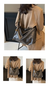 Close-up of black glossy leather tote bag with braided tassel and golden bead detail