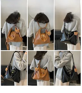 Detail view of large matte leather tote bags in black and brown with bear charms