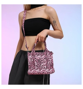 Pink leopard print tote bag with adjustable shoulder strap shown on a model