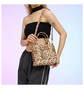 Detailed view of women's leopard print crossbody bag with handles and adjustable strap
