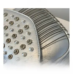 Detailed close-up of silver PU leather bag featuring metallic rivets and crystal fringes