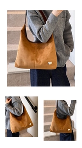 Detail of a brown suede hobo bag with heart metallic buckle and leather shoulder strap