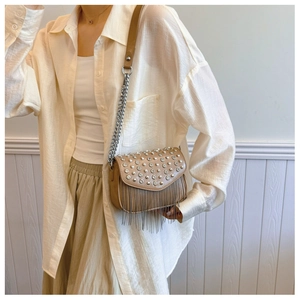 Detail of tan PU leather crossbody bag featuring silver rhinestone studs and metallic fringe
