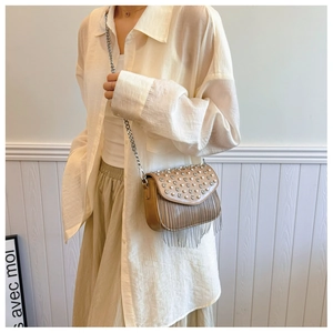 Detail of khaki PU leather bag featuring elegant rhinestone patterns and silver metal tassels