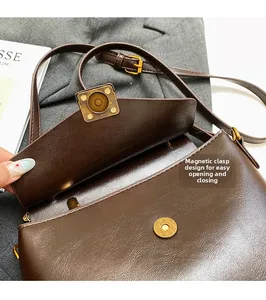 Close-up of magnetic snap closure and texture on vintage brown pebbled leather bag