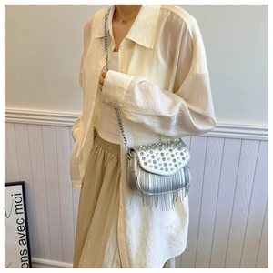Close-up of sparkling silver rhinestone crossbody bag with elegant long chain tassels