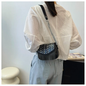 Detail of black PU crossbody bag with sparkling rhinestones and silver metal fringes