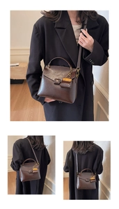 Detail of a vintage dark brown leather handbag with mini lock charm and adjustable strap
