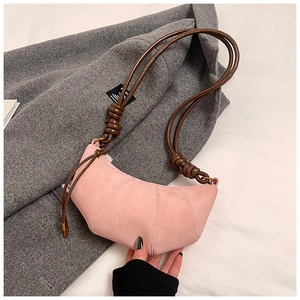 Detail of pink suede dumpling bag with brown leather knotted strap on wool coat