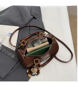 Detail view of the spacious interior of this brown leather cylinder Boston handbag