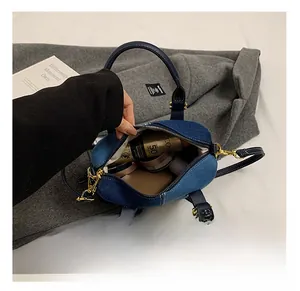 Macro view of denim Boston bag interior showing spacious storage for cosmetics