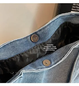 Detail view of denim shoulder bag with hidden magnetic snap button and fabric lining