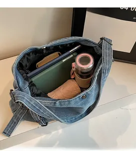 Spacious interior of large denim shoulder bag showing room for tablet and daily items