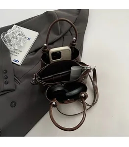 Vue intérieure du sac seau marron montrant l'espace pour cosmétiques et téléphone