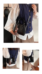 Détail d'un sac seau noir en cuir ciré avec charm ours et bandoulière réglable pratique