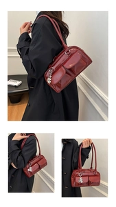 Close-up of a burgundy patent leather tote bag with front flap pockets and silver heart charm
