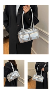 Detail of metallic silver tote bag featuring double front pockets and heart metal charm