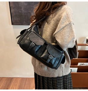 Detail of retro shoulder bag featuring dual metallic buckle pockets and black PU texture
