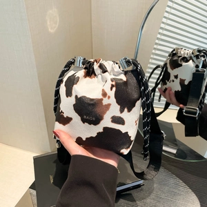Fashion cow print bucket shoulder bag for women, trendy crossbody bag with drawstring design.