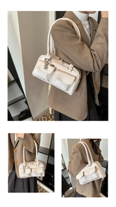 Close-up of white glossy patent leather tote with heart charms and pockets