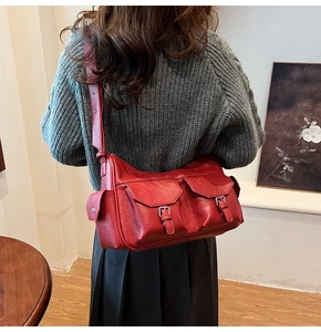 Close-up of deep red vintage PU leather crossbody bag with multiple functional pockets