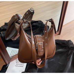 Dettaglio della borsa sottobraccio in pelle PU lucida marrone con cinturini con occhielli