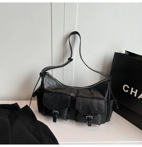 Detail of black vintage faux leather bag with adjustable strap and two front pockets