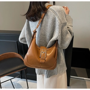 Borsa hobo sottobraccio vintage marrone con fibbia in metallo indossata vista posteriore