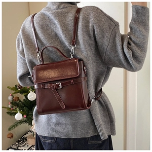 Dunkel burgunderrote Rucksack-Tasche aus Wachsleder mit Schnalle am Modell