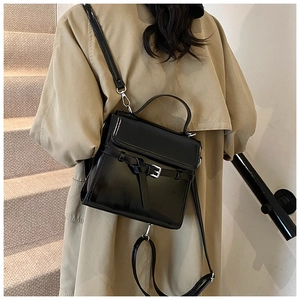Detailansicht der schwarzen Lackledertasche mit Schnallenknoten und silbernen Beschlägen