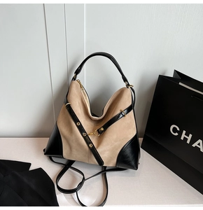 Close-up of color-block tote bag with beige suede, black leather and gold hardware