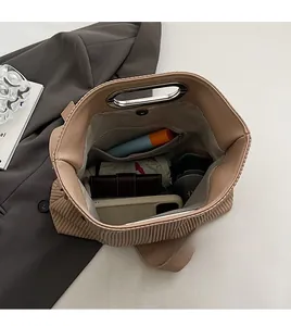 Macro shot of spacious beige pleated handbag interior filled with daily essentials