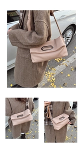 Detail of pink pleated crossbody bag with oval metal buckle shown in outdoor lifestyle setting