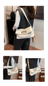 Detail showing white corduroy shoulder bag with silver oval metal buckle and leather strap