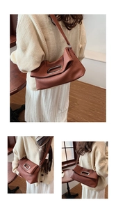 Close-up of caramel pleated shoulder bag with silver oval metal handle and textured finish