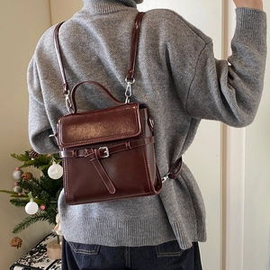 Minimalist dark brown leather backpack for women in winter style with top handle and silver clasp