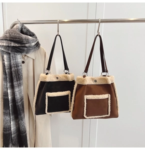 Detail of suede tote bag with faux shearling trim in black and brown colors