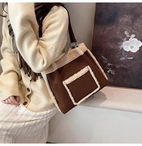 Detail of vintage suede tote bag with white faux shearling trim and brown leather strap
