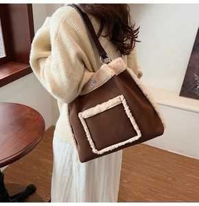 Detail of plush lamb wool trim on brown suede shoulder bag with long leather strap