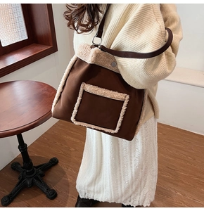 Close-up of brown plush bucket bag with white faux fur trim and metal ring hardware