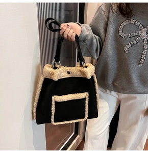 Detail of faux shearling trim on black tote bag with long handles and metal rings