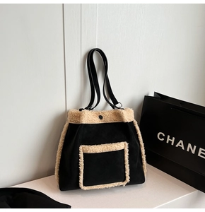 Macro detail of plush faux shearling trim on a black tote bag with premium metal snap button