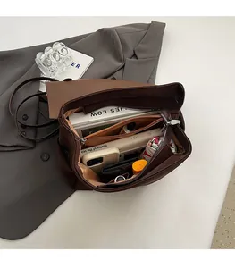 Top view of open dark brown tote bag interior with zipper pocket and daily essentials