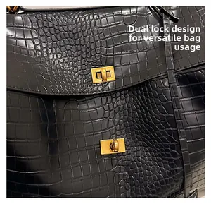 Detail view of black crocodile pattern bag featuring double golden twist-lock design