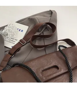 Détail d'un sac cabas marron avec poignée en corde tressée et large bandoulière en toile