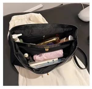 Spacious interior of black croc-pattern tote bag showing storage for daily essentials