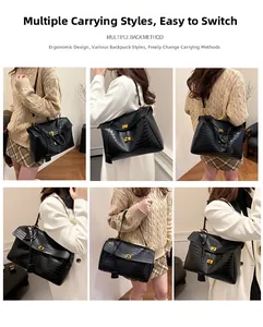 Detail of black crocodile texture tote bag with golden twist lock and multiple carrying styles