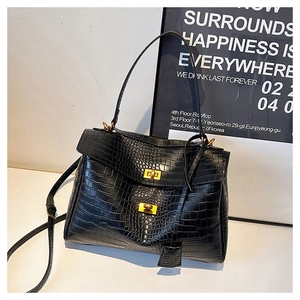 Detail of crocodile embossed leather tote with elegant golden twist-lock closure