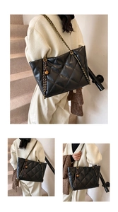 Detail view of quilted black tote bag with chain strap and gold sphere charm
